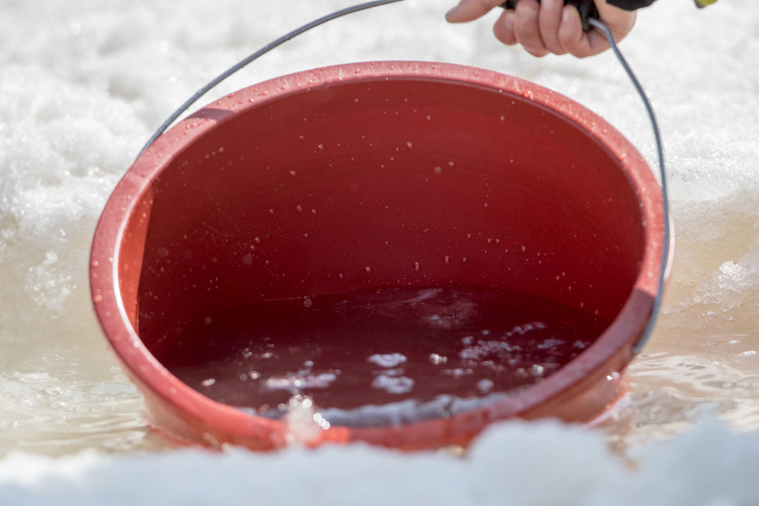 フィニッシュエリアでは、大会関係者が雪水を1ヶ所に流れ集まりようにし、そこからバケツで水を汲み出していた（撮影：越智貴雄）